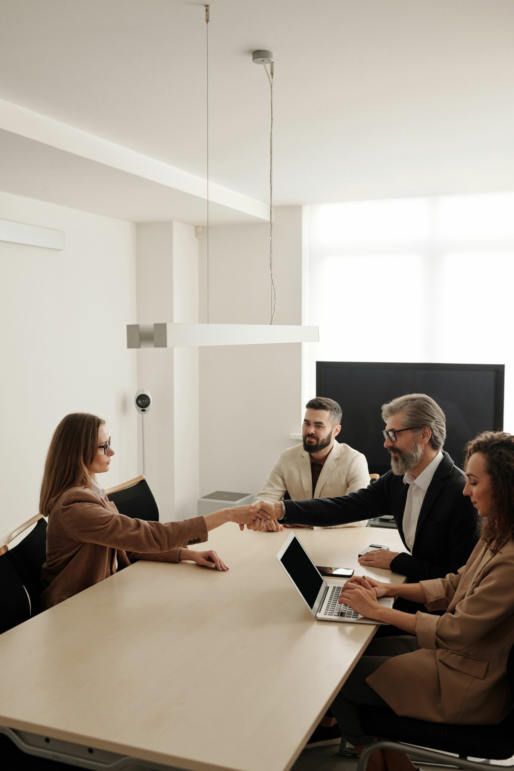 Réunion professionnelle avec poignée de main illustrant une demande de devis d’assurance professionnelle